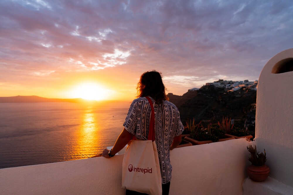 Intrepid Travel Greece Santorini sunset traveller facing water